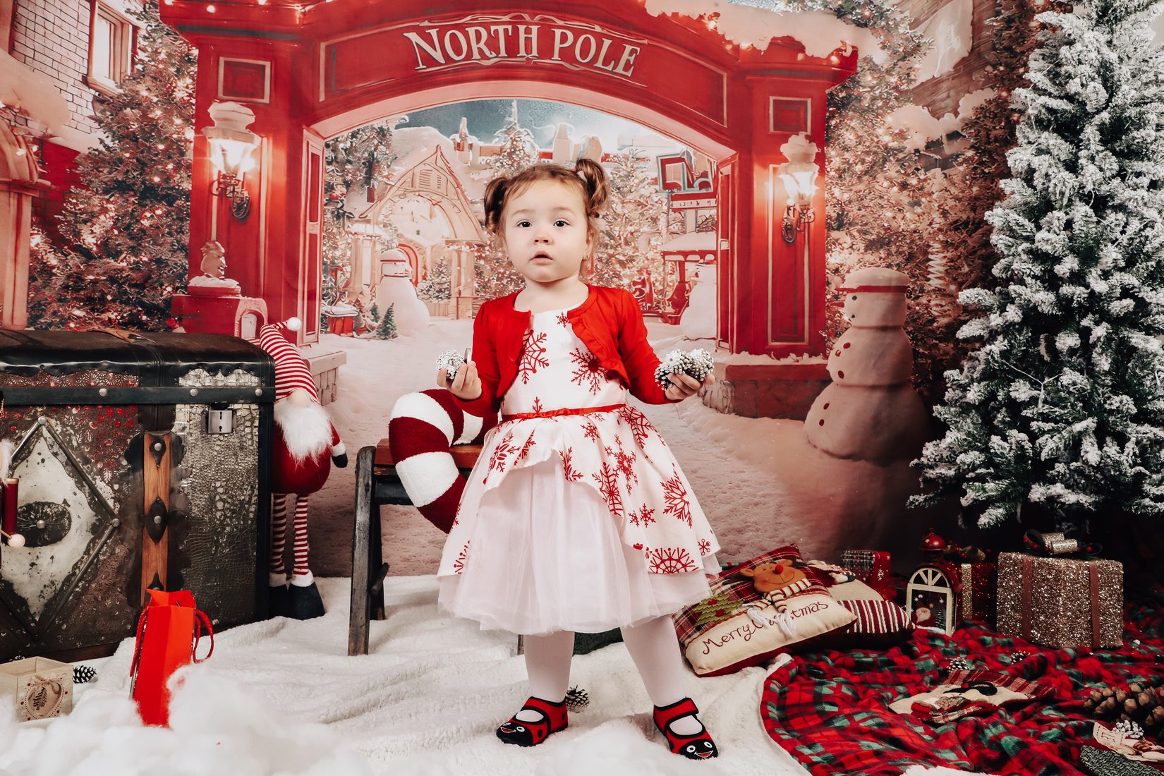 Момиченце в коледна рокля пред North Pole